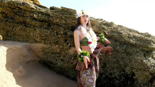 Beautiful woman performing hawaiian dancing at the beach
