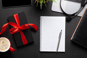 Gift box on office desk table and blank notepad