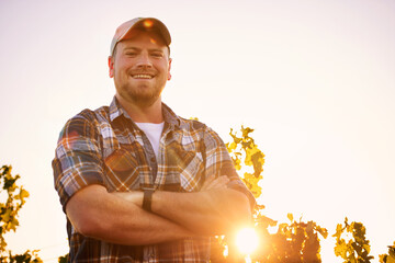 Im the master of this vineyard. Portrait of a happy farmer posing with his arms crossed in a vineyard.