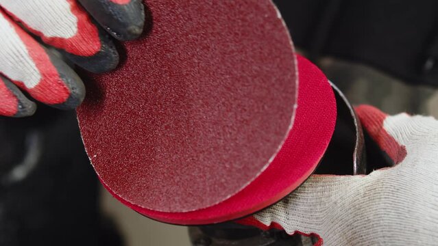 Closeup of the support disc of angle grinding with Velcro on which round sandpaper is attached. Builder attaches an emery to angle grinder for grinding