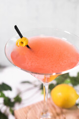 Orange martini with lemons on light background