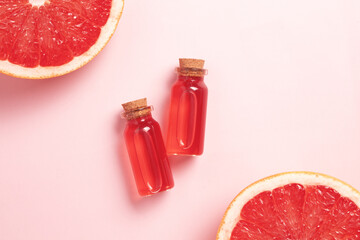 Little glass vial of aroma essential oil wich grapefruit fresh slice. Flat lay, top view face serum...