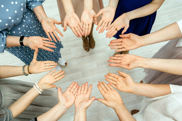 A circle of female hands, palms up