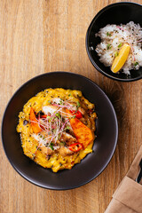 chicken curry with a black plate on a wooden background. restaur
