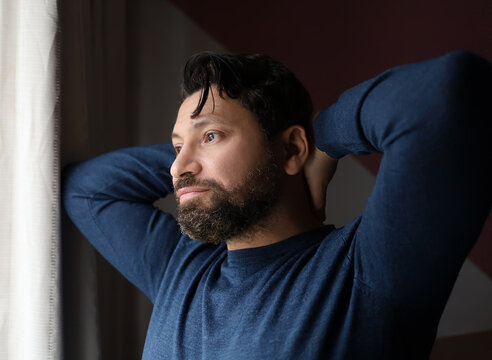 Handsome man stretching and look at window