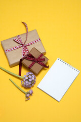 on a yellow background lilac primrose flowers, notepad, gift box. card, congratulations on March 8