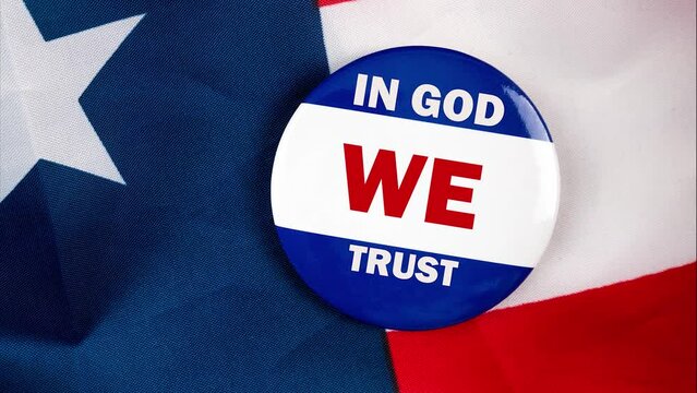 in god we trust text quote on election button laying on the star spangled banner. united states of america concept.