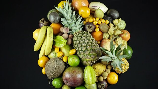 Rotating Exotic Fruits On Black Background Top View.