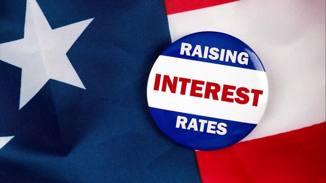 raising interest rates text quote on election button laying on the star spangled banner. united states of america concept.