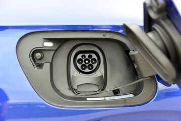 Electric vehicle charging socket by protective cover