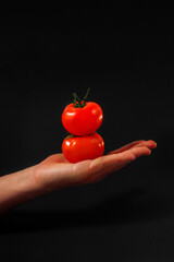 two tomatoes in the palm of a man