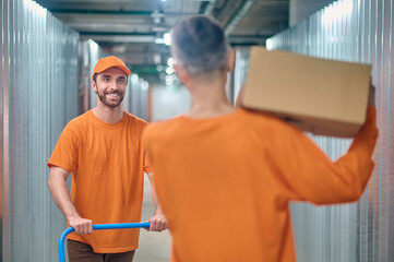 Two warehouse loaders working in the storage room