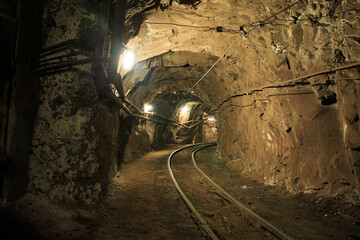 Narrow gauge railroad in the underground mine horizon. Technologies of mining of minerals by the underground method. Underground mine for mining ore