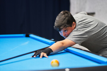 Boy preparing to hit ball during pool game