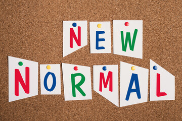 The words new normal are standing in colorful letters on pinned paper, changing world, different...