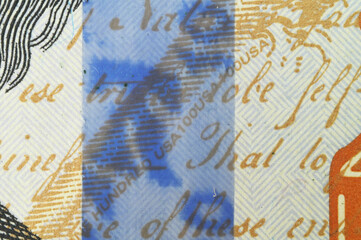 close-up is a three-dimensional blue stripe with a holographic image on one hundred US dollars.