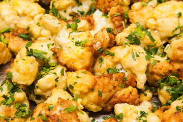 Fried cauliflower sprinkled with chopped green onions. Brassica oleracea.