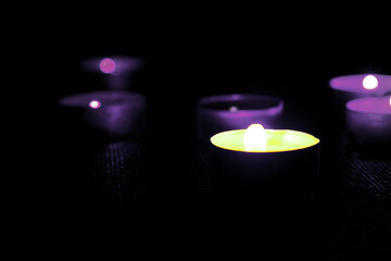 Candles Burning on a Black background With Soft focus. White candles burning in the dark with a focus on one candle.The Concept of Grief, Mourning.