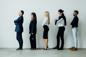 Obraz premium Full length side view of business people walking in queue against white background