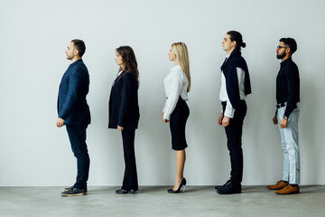 Full length side view of business people walking in queue against white background