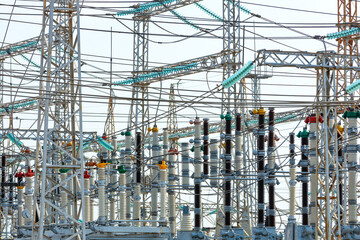 A web of electrical wires and high-voltage dielectric insulators on the metal masts of a substation...