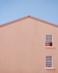 Obraz premium Gable house front view with pink wall and blue sky.Minimal concept.3d rendering