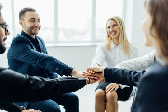 Successful diverse multiracial business team giving a high fives gesture as they celebrate in a conference room in an office - Powered by Adobe