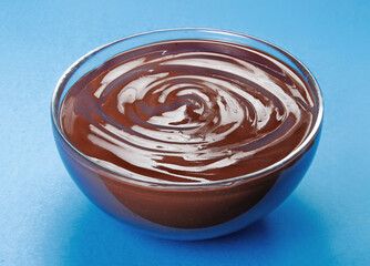 Fresh dark chocolate cream bowl on blue background