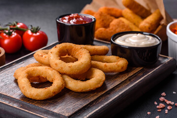 Homemade crunchy fried onion rings with tomato sauce