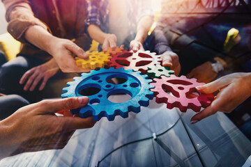 Business team connect pieces of gears like a teamwork and partners - obrazy, fototapety, plakaty