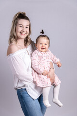 junge, lachende frau hält lachendes baby im Arm