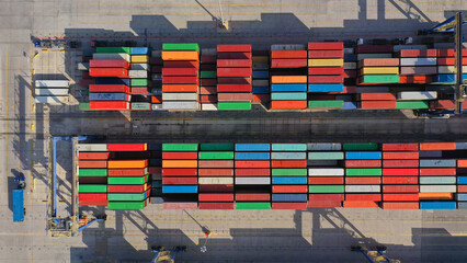 Aerial drone top down photo of industrial logistics unloading import and export container terminal...