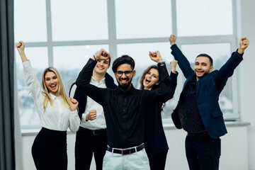 Portrait of happy business team celebrating victory in office