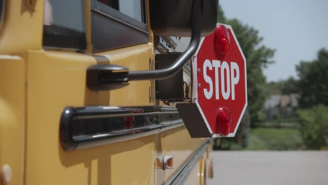 fast dolly shot of School bus stop sign opening