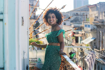 Young afro woman is standing happy in the balcony