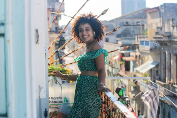 Young afro woman is standing happy in the balcony