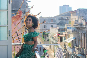 Young afro woman is standing happy in the balcony