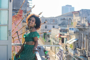 Young afro woman is standing happy in the balcony