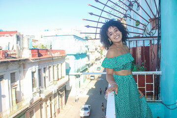 Young afro woman is standing happy in the balcony