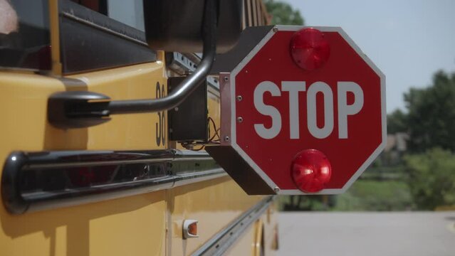 dolly shot of School bus stop sign opening and flashing