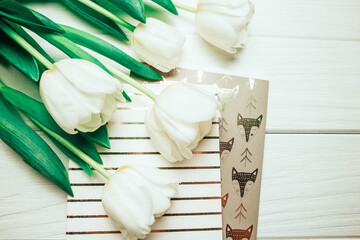 Fototapeta na wymiar Tulips on wooden background with notepads. In spring