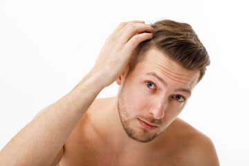 The young man was upset when he noticed his gray hair. Hair care, baldness graying.