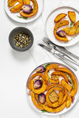 Roasted pumpkin,onion and garlic with thyme and rosemary on white background. Rustic food photography.  Close-up. Top view.