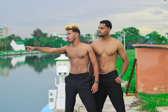 Two young Afro men talk on the coast. 
