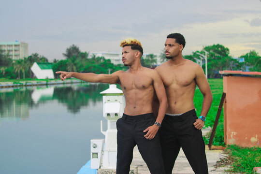 Two young Afro men talk on the coast. 