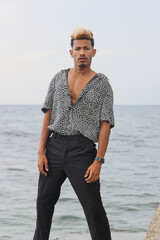 Portrait of cool young african man dancing at the beach on summer day
