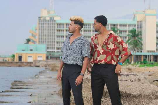Two young Afro men talk on the coast. 