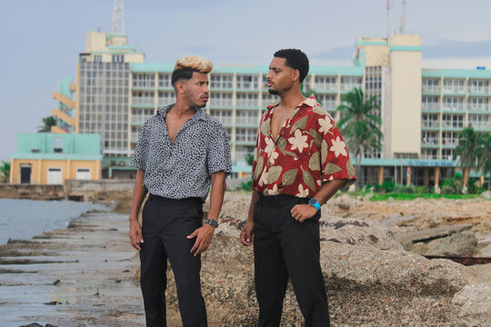 Two young Afro men talk on the coast. 