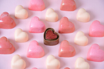 Chocolate bonbons in the shape of pink hearts.