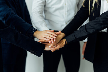 International business team showing unity with their hands together in office